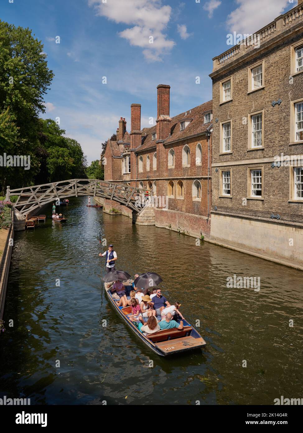 The Mathematical Bridge across the river Cam and summer tourists punting at Queens College in Cambridge Cambridgeshire England UK Stock Photo