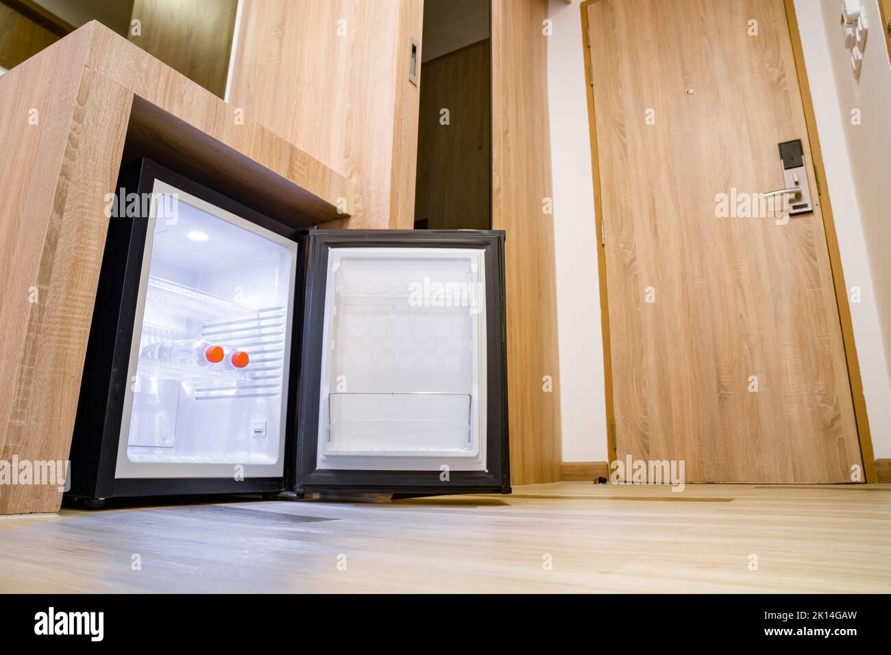 Refrigerator fridge mini size under the table counter with wooden desk  beside it in hotel delux room Stock Photo - Alamy