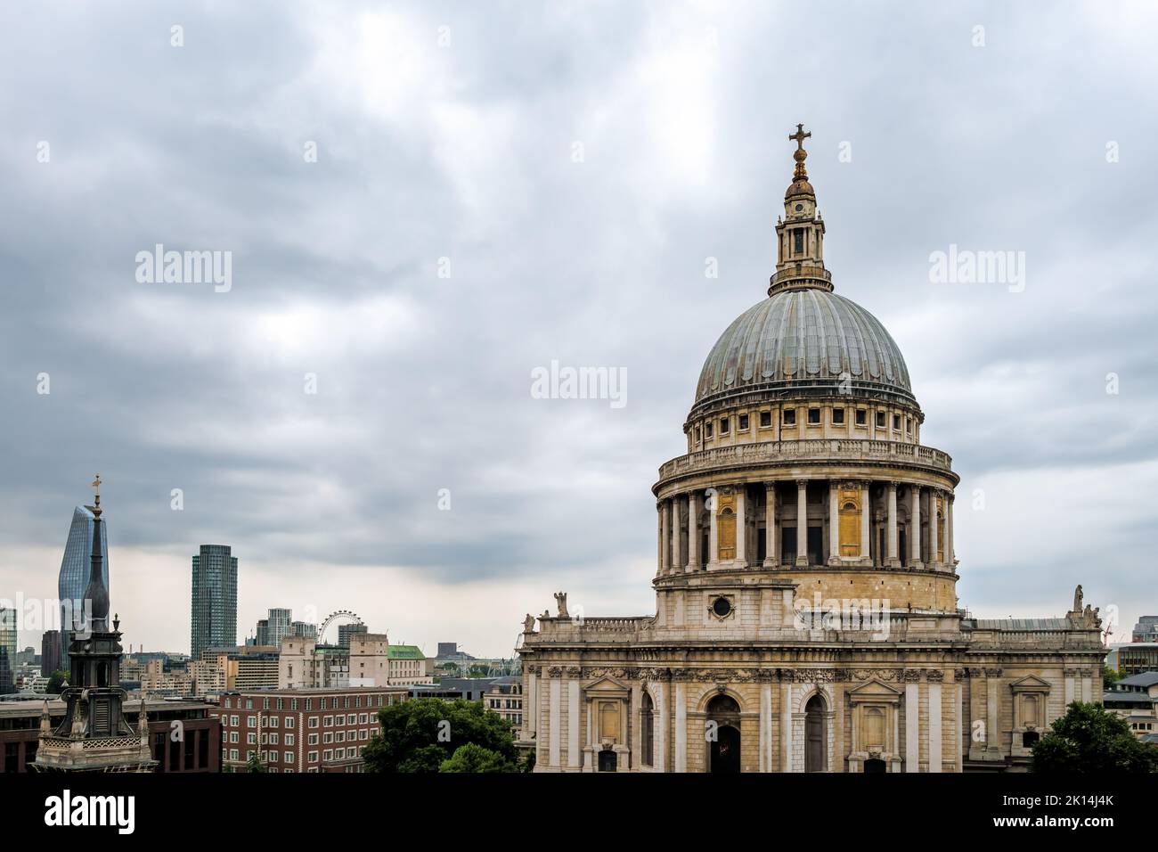 LONDON, ENGLAND - JULY 21st, 2022: View of Saint Paul Cathedral's dome on a cloudy summer afternoon, buildings and London Eye in the back ground Stock Photo
