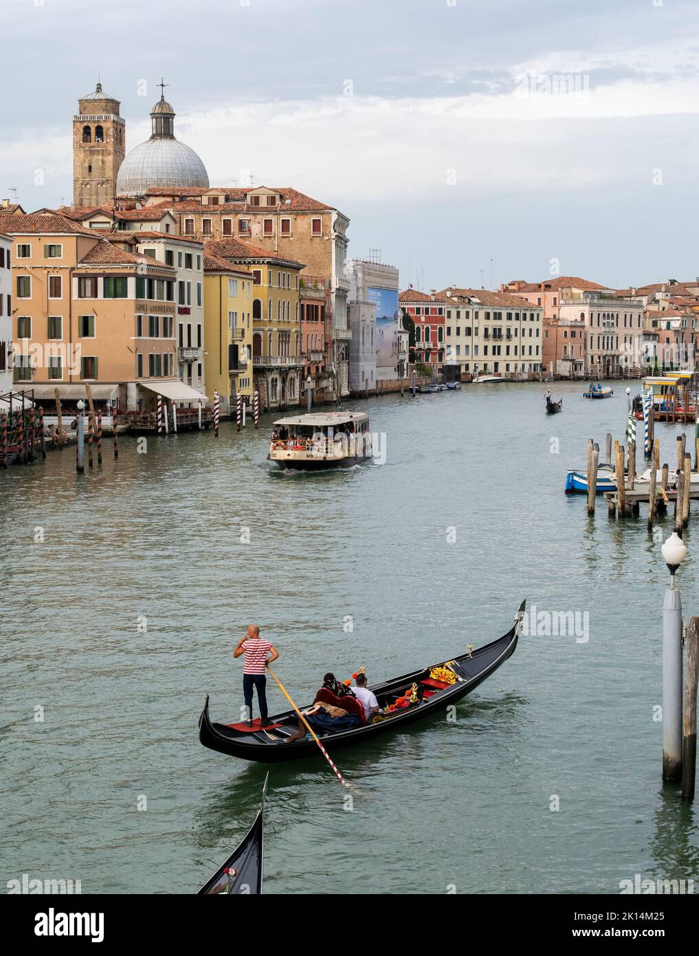 Tourists travelling at gondolas, typical boats, at the town of Venice, Italy Stock Photo