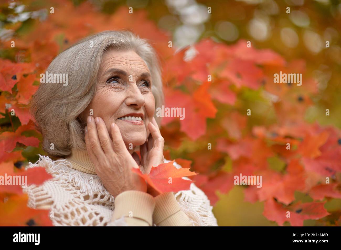Senior woman walking in the park in autumn Stock Photo - Alamy