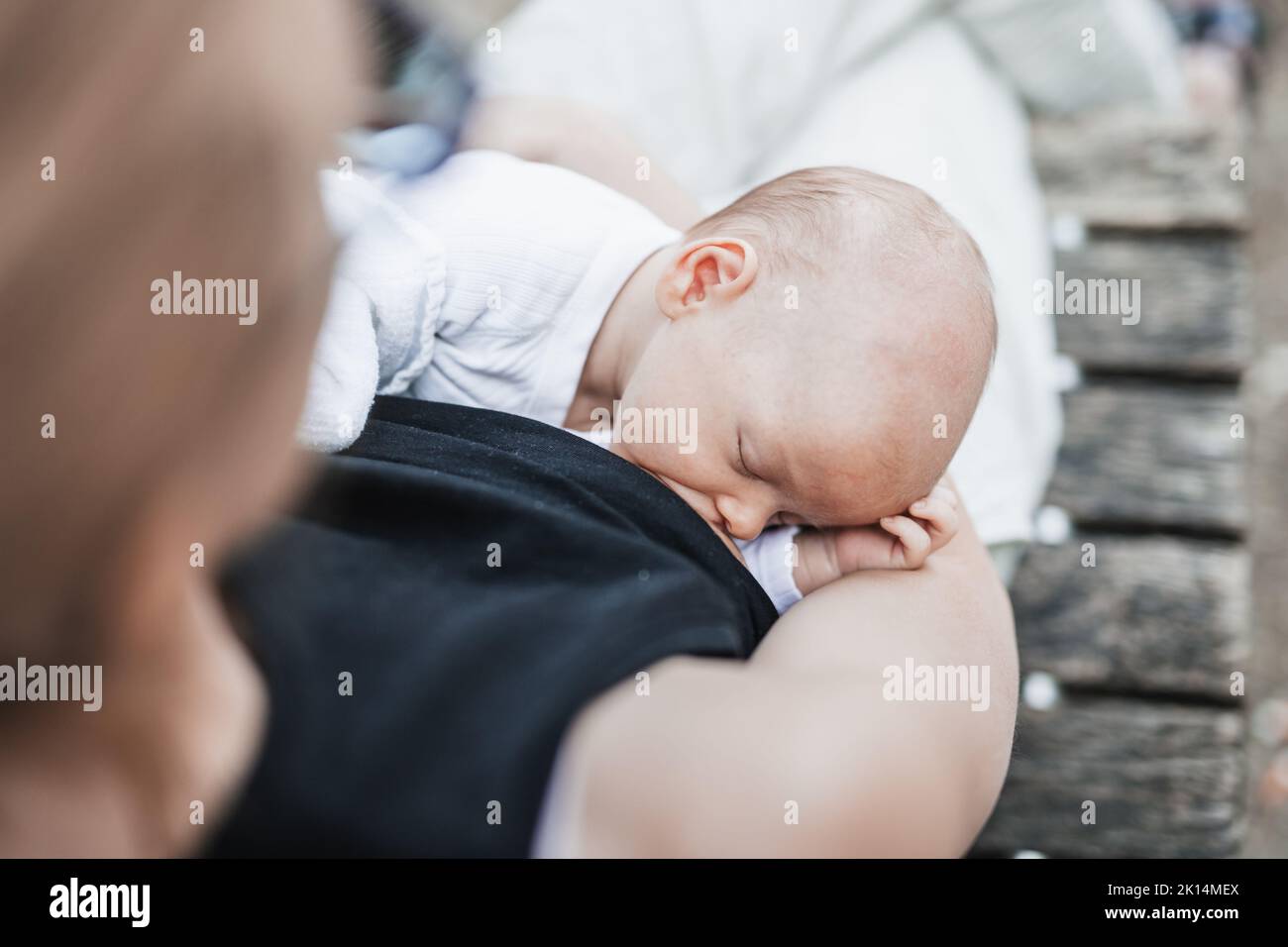 Mother breast feeding and hugging her baby boy outdoors.  Stock Photo