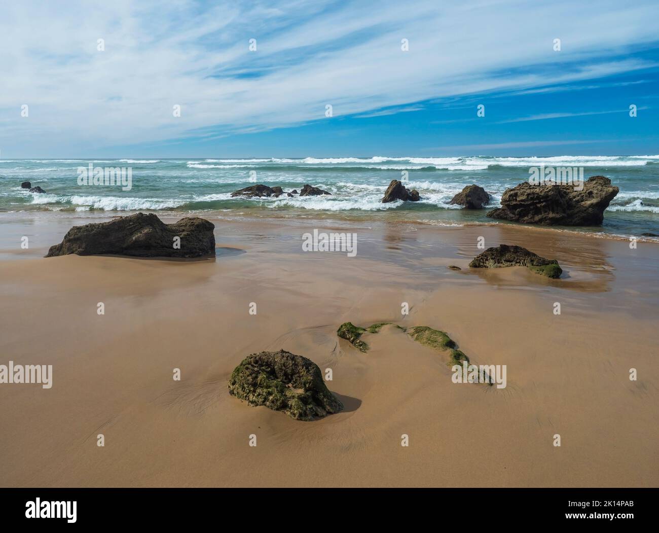 View of empty Praia do Queimado beach with ocean waves and sharp rocks ...