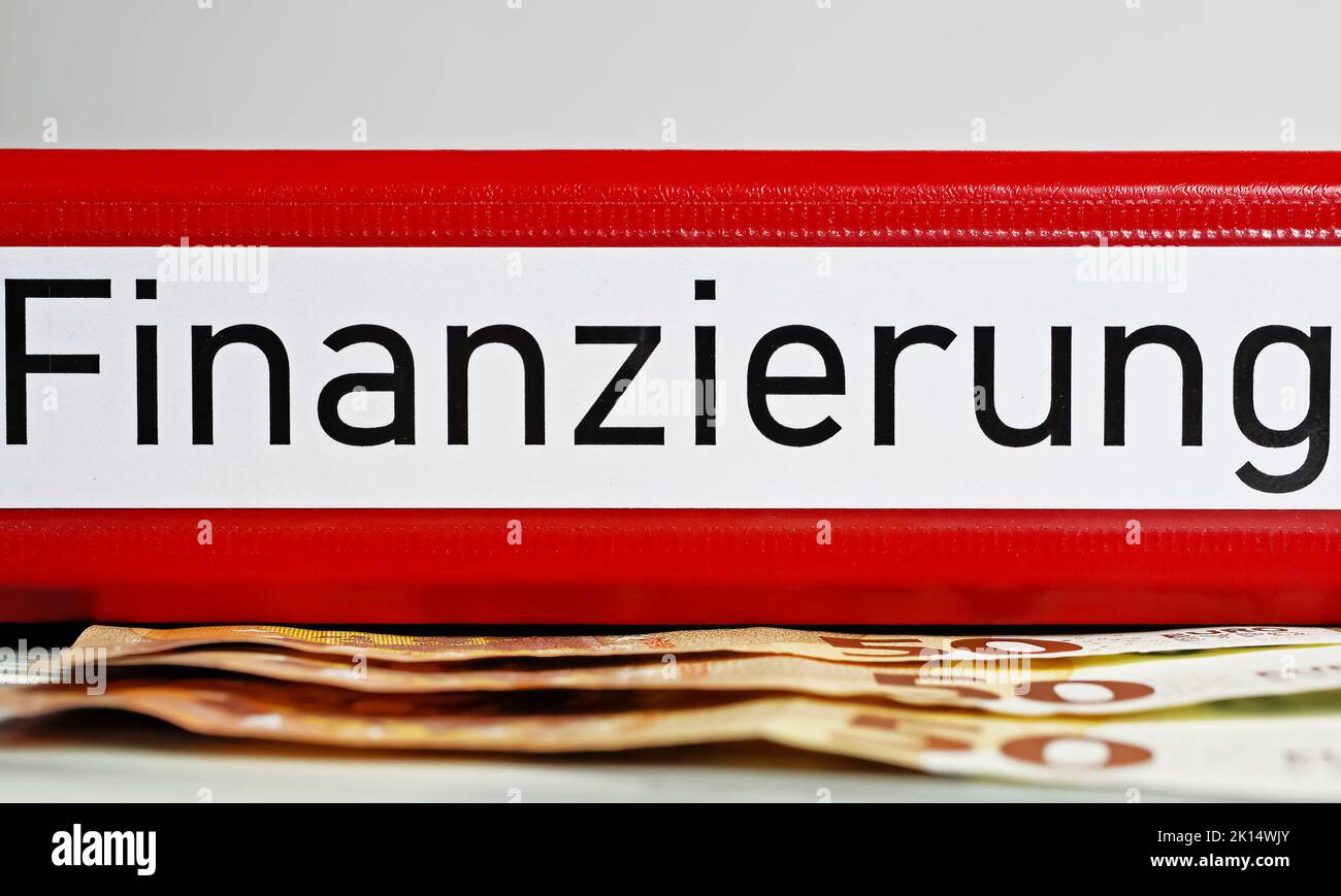 Closeup of isolated red file folder with german word Finanzierung (engl. Translation: financing), euro money banknotes Stock Photo
