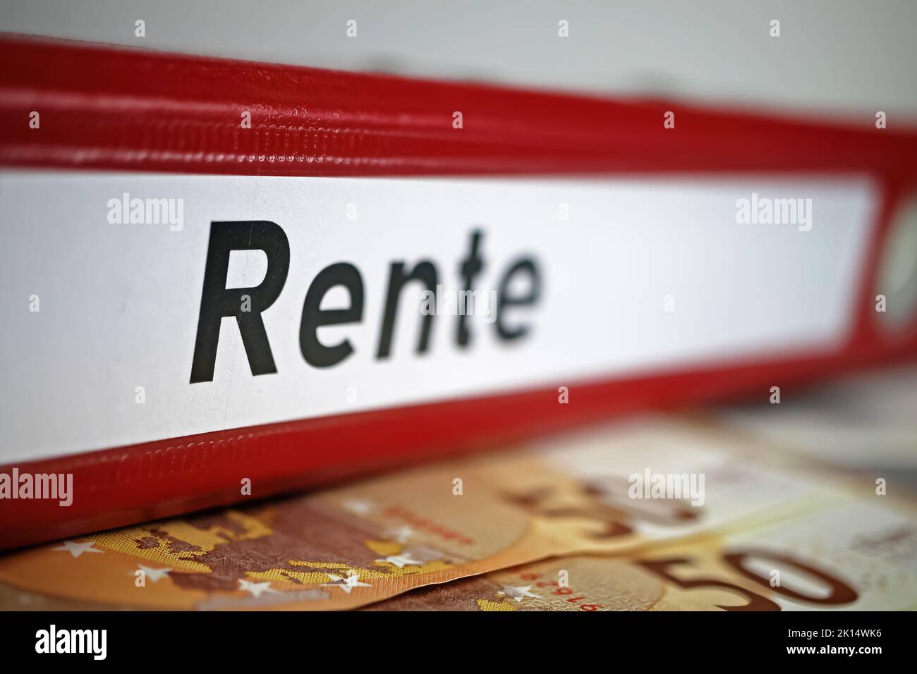 Closeup of isolated red file folder with german word Rente (engl. translation: pension), euro money cash banknotes Stock Photo