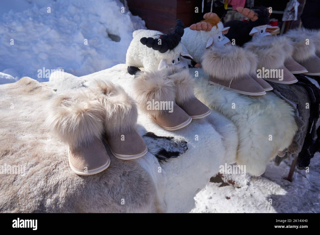 Warm slippers with fur are sold at the street market. Stock Photo