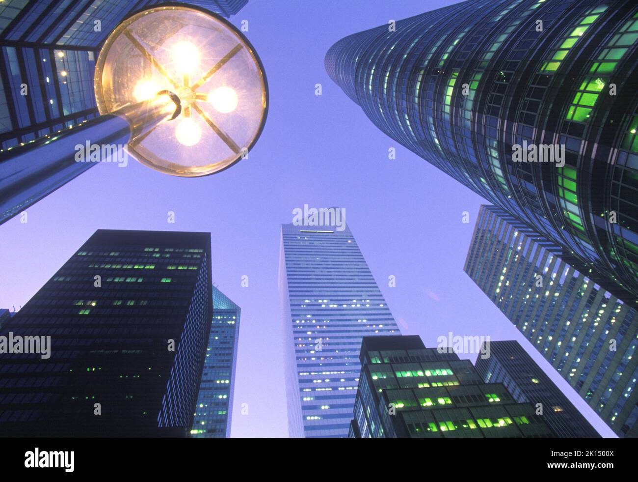 Skyscrapers at night Midtown Manhattan. Low angle perspective view of office buildings against an early evening sky in New York City. USA Stock Photo
