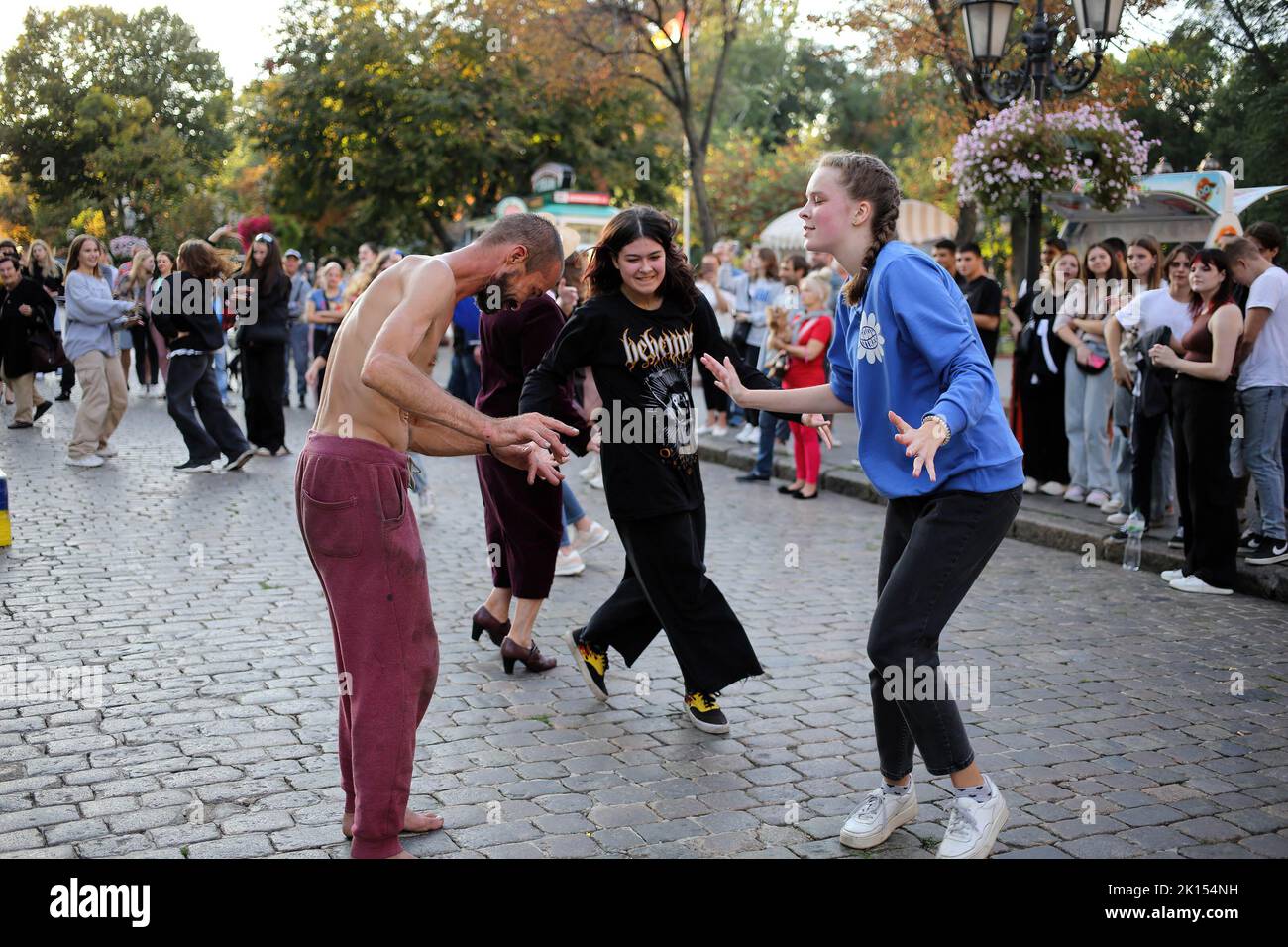 People are seen dancing to the street music band. Despite the full-scale invasion of the Russian Federation, on the weekends, joy and life reign on the main street of Odessa - Deribasovskaya, vacationers walk, dance, having fun, as in peacetime. Deribasovskaya street - one of the central streets of the city of Odessa, is one of the main attractions of the city.Since the end of the 20th century, most of Deribasovskaya has been closed to traffic and is a pedestrian zone. Deribasovskaya is a popular place for festivities. There are numerous cafes and shops on Deribasovskaya. The street got its na Stock Photo