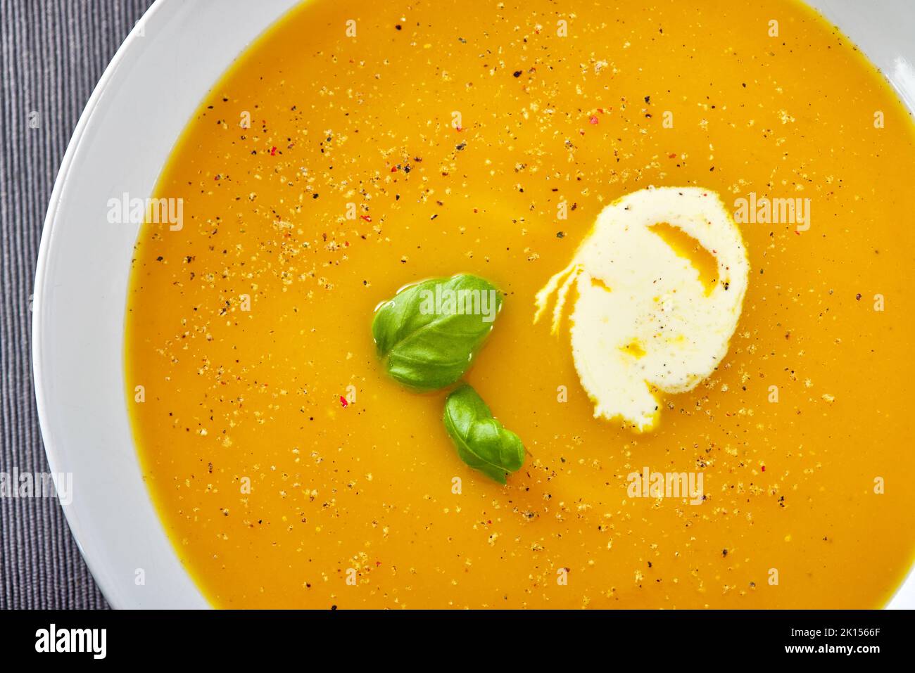 Pumpkin traditional soup with sour cream. Close up Top view. Stock Photo