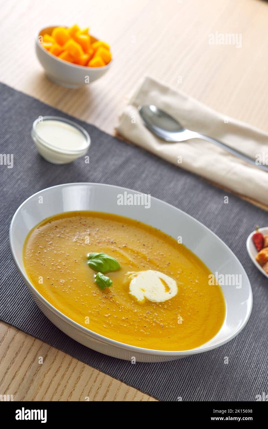 Pumpkin traditional soup with croutons and sour cream Stock Photo