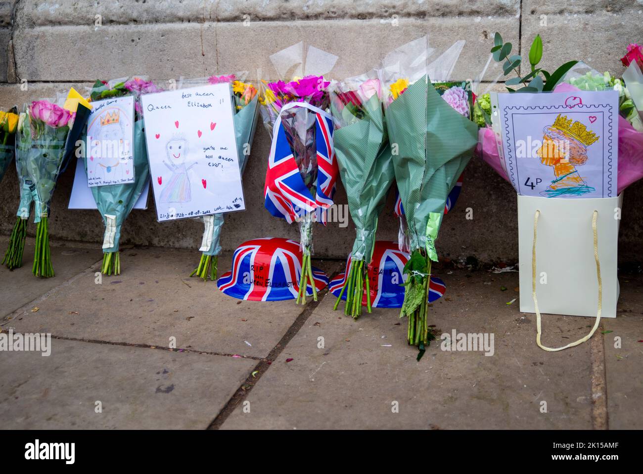 Flowers and messages left outside Buckingham Palace following the death of Queen Elizabeth II. Plastic wrapped bouquets with personal messages Stock Photo