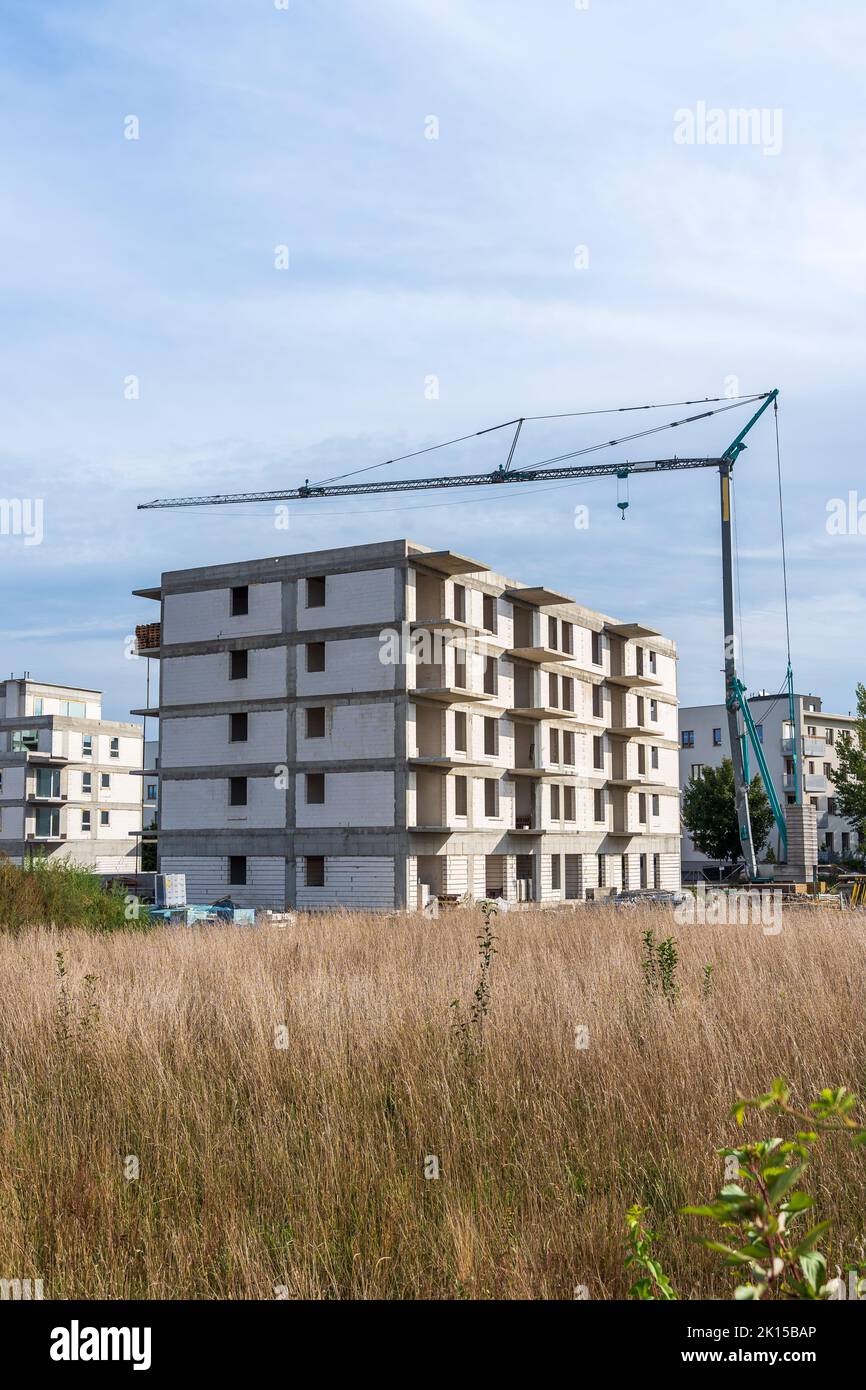 Construction of a housing estate with white walls. Tower crane Stock Photo