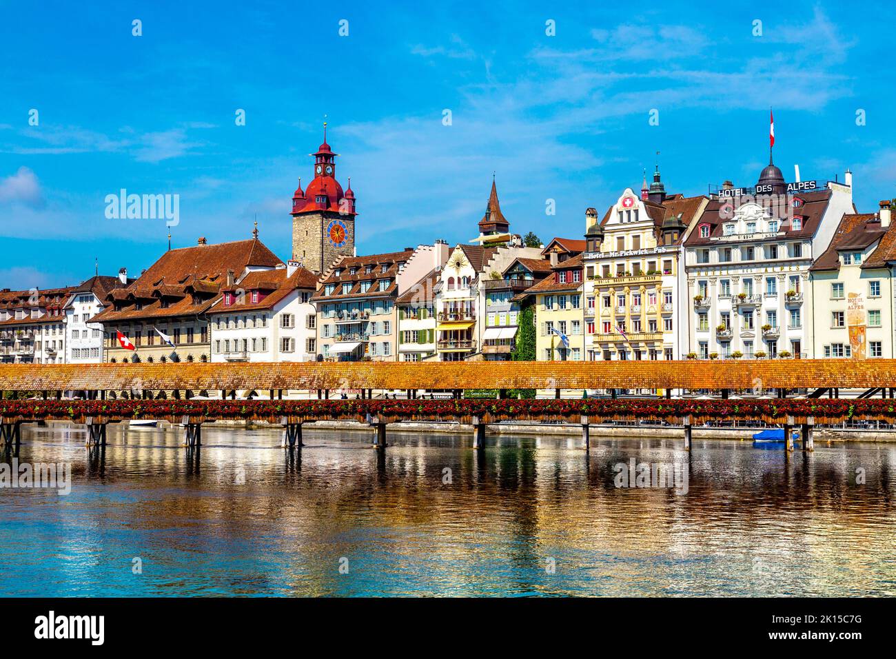 View of houses along the bank of River Russ and the wooden Chapel Bridge (Kapellbrücke), Lucerne, Switzerland Stock Photo