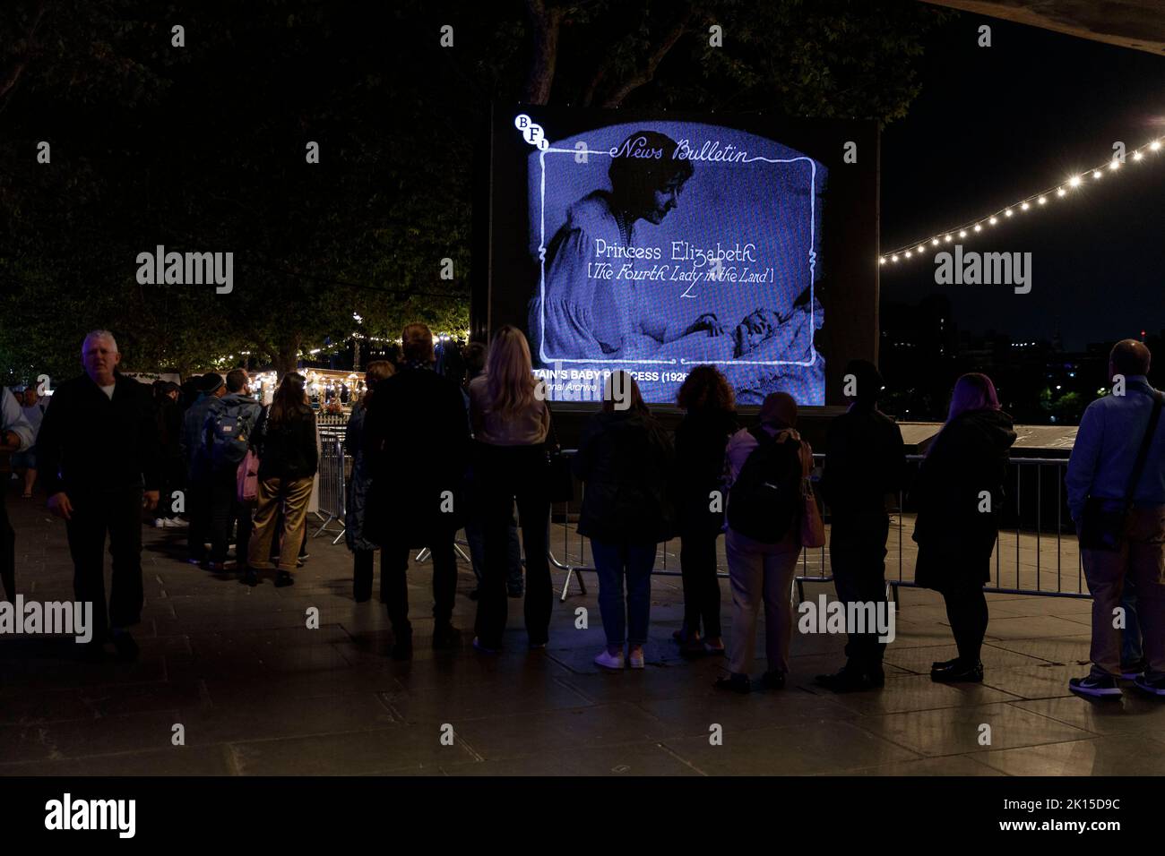 An outdoor screen showing baby Queen Elizabeth II along the queue at ...