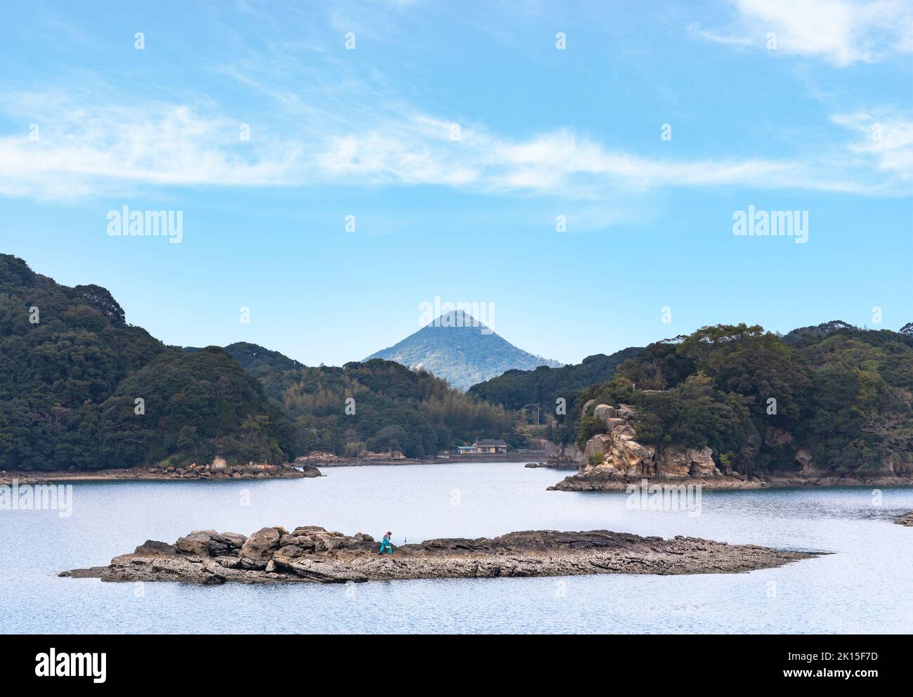 kyushu, japan - december 09 2021: A japanese oyster farmer wearing a chest waders walking on an islet to collecting shellfish used for the pearl oyste Stock Photo