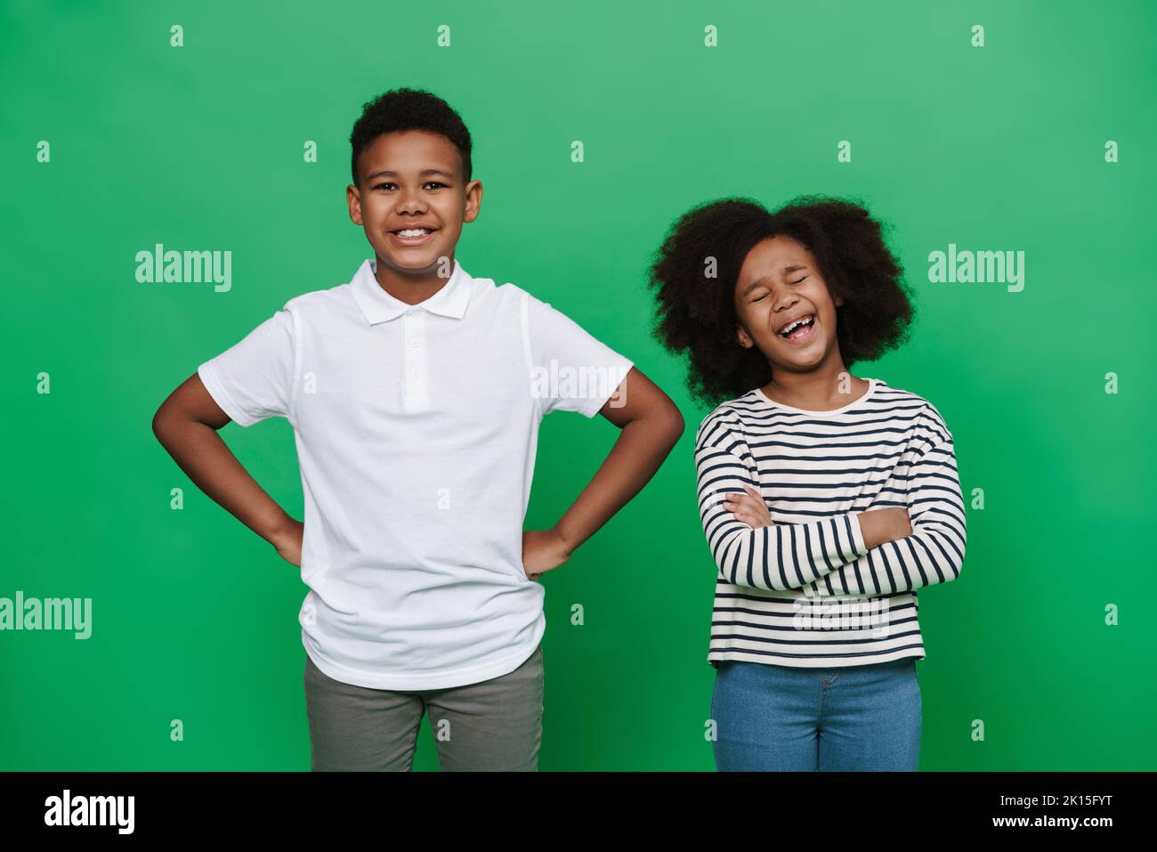 Black boy and girl laughing while posing together at camera isolated ...