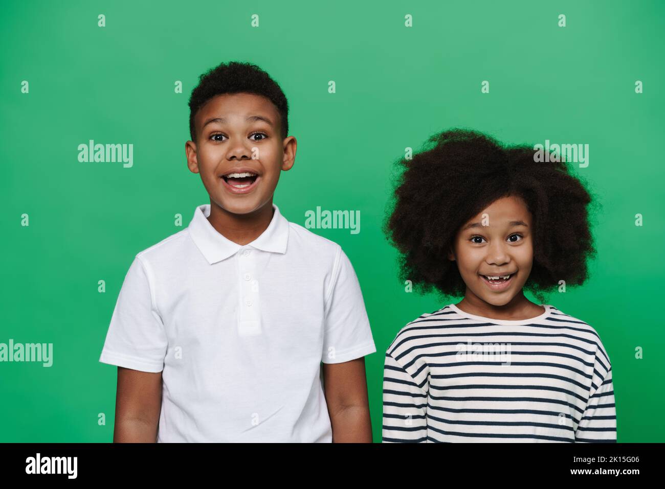 Black boy and girl smiling while looking together at camera isolated ...