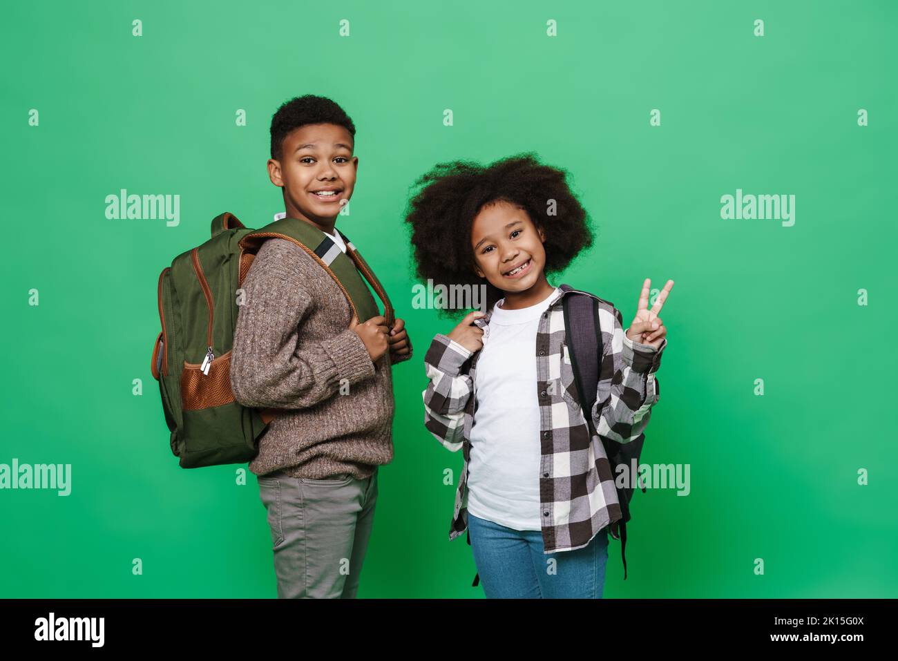 Black boy and girl showing peace gesture while smiling together ...