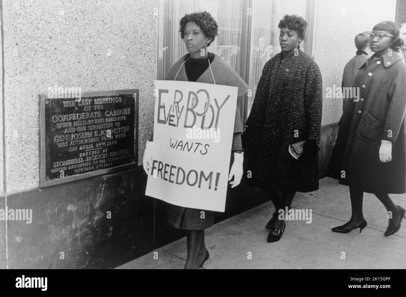 Protesting segregation, these demonstrators walked past this Charlotte, NC building where the last meeting of the Confederate cabinet was held. The demonstrators are protesting that a movie theater in this building would only seat African Americans in the balcony; February, 1960. Stock Photo