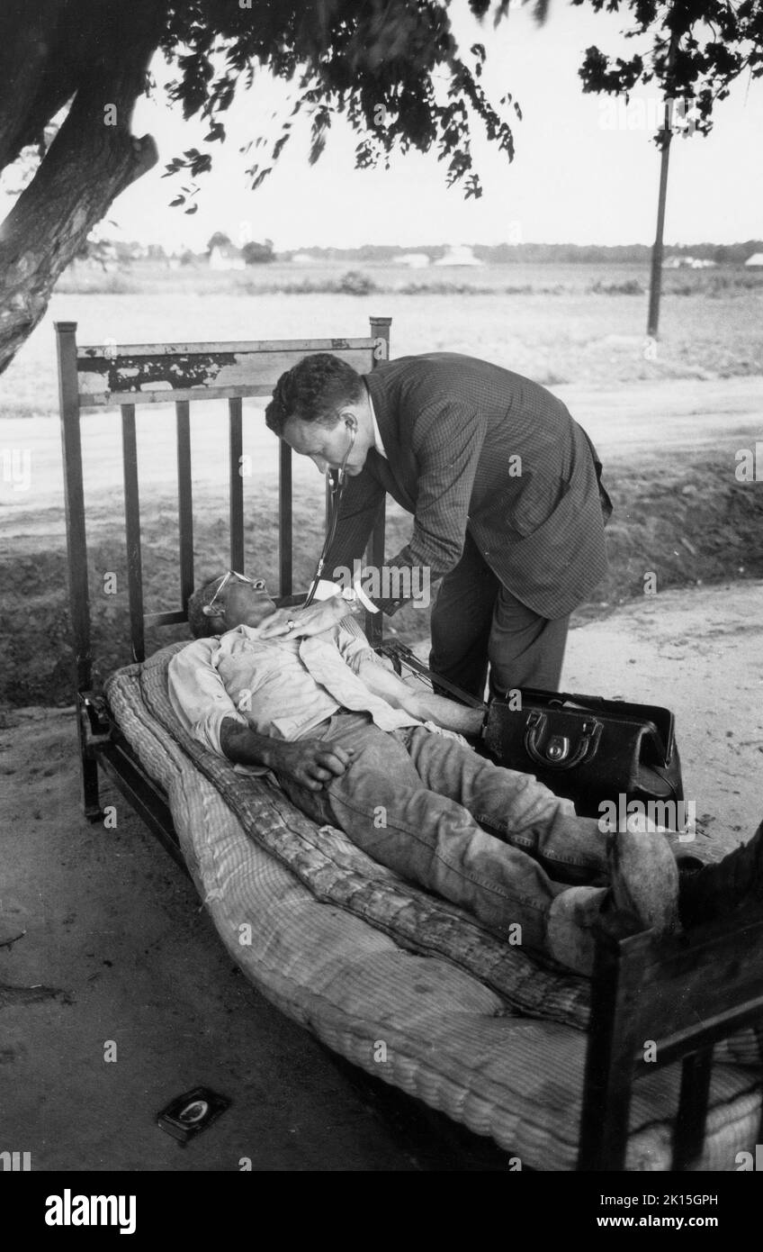 In 1961, Dr. Lloyd McGaskill examines a patient near Maxton, NC. Stock Photo