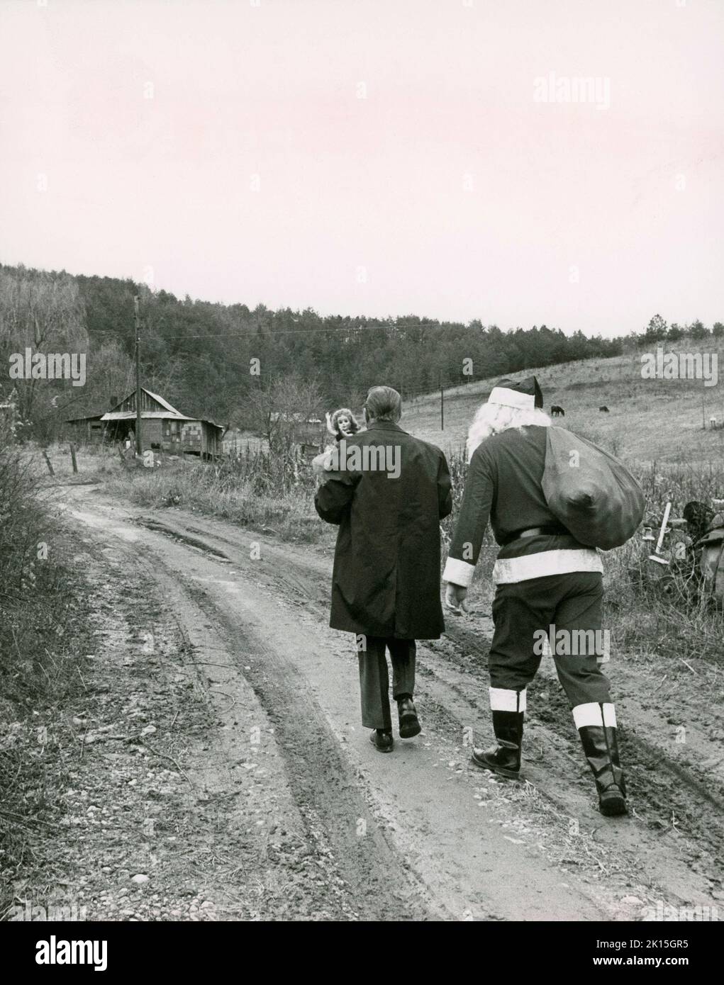 Santa Claus brings presents to children in Appalachia, thanks to the Parson of the Hills; 1965. The charity was set up to provide gifts to the children of the Appalachias. Here, the Parson and Santa come on foot, as the road was not passable for the truck. Stock Photo
