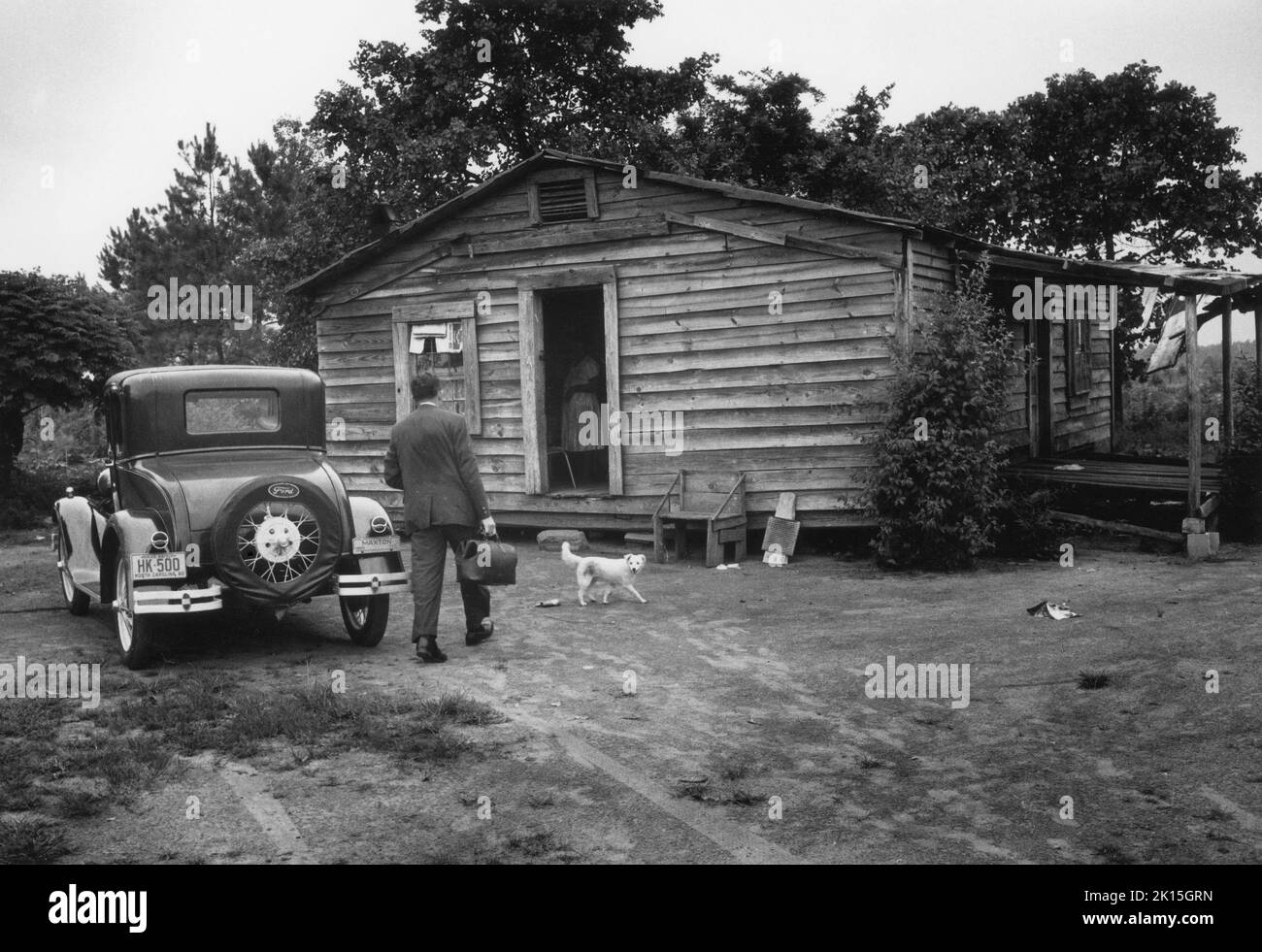 In 1961, Dr. Lloyd McGaskill makes a house call near Maxton, NC. He was a car enthusiast, and often drove an antique Ford he owned. Stock Photo