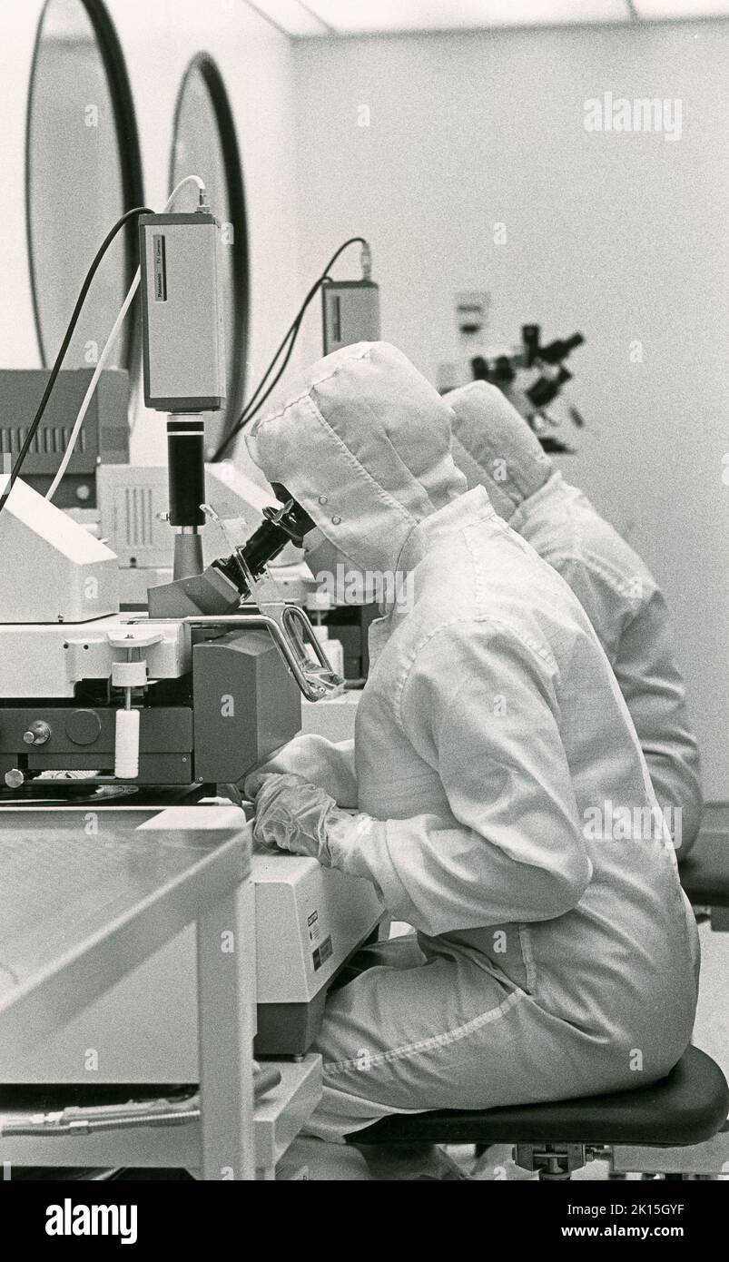 Historic image, (1984), of technicians inspecting wafers in a clean ...