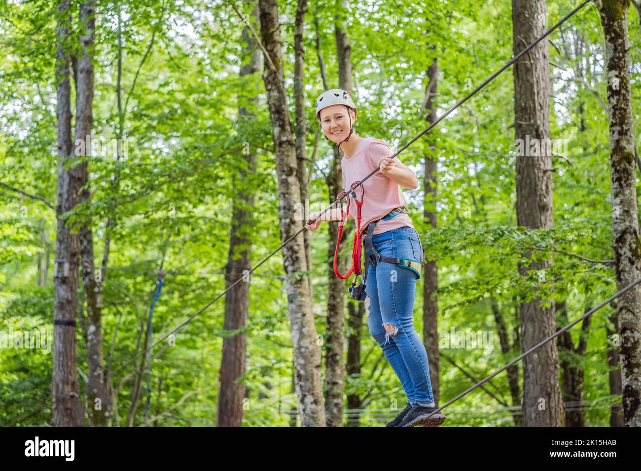 Mother and son climbing in extreme road trolley zipline in forest on ...