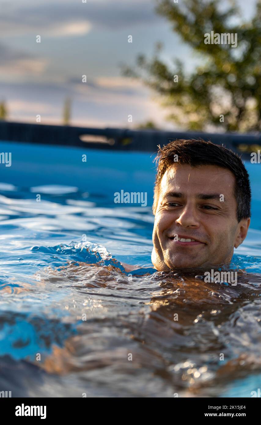 Handsome man swimming and enjoying in backyard pool Stock Photo Alamy