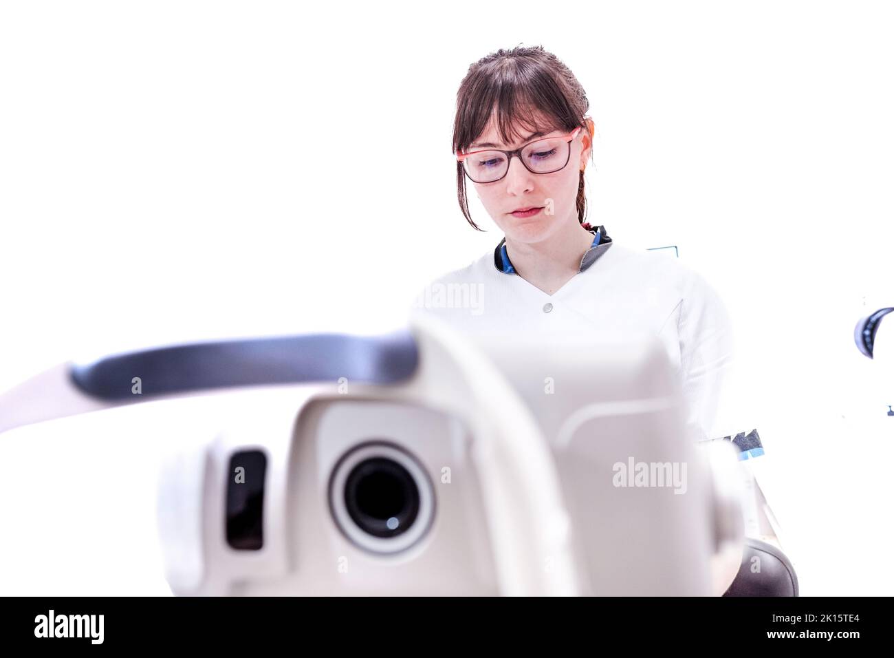 Low angle of concentrated female doctor in uniform working in modern