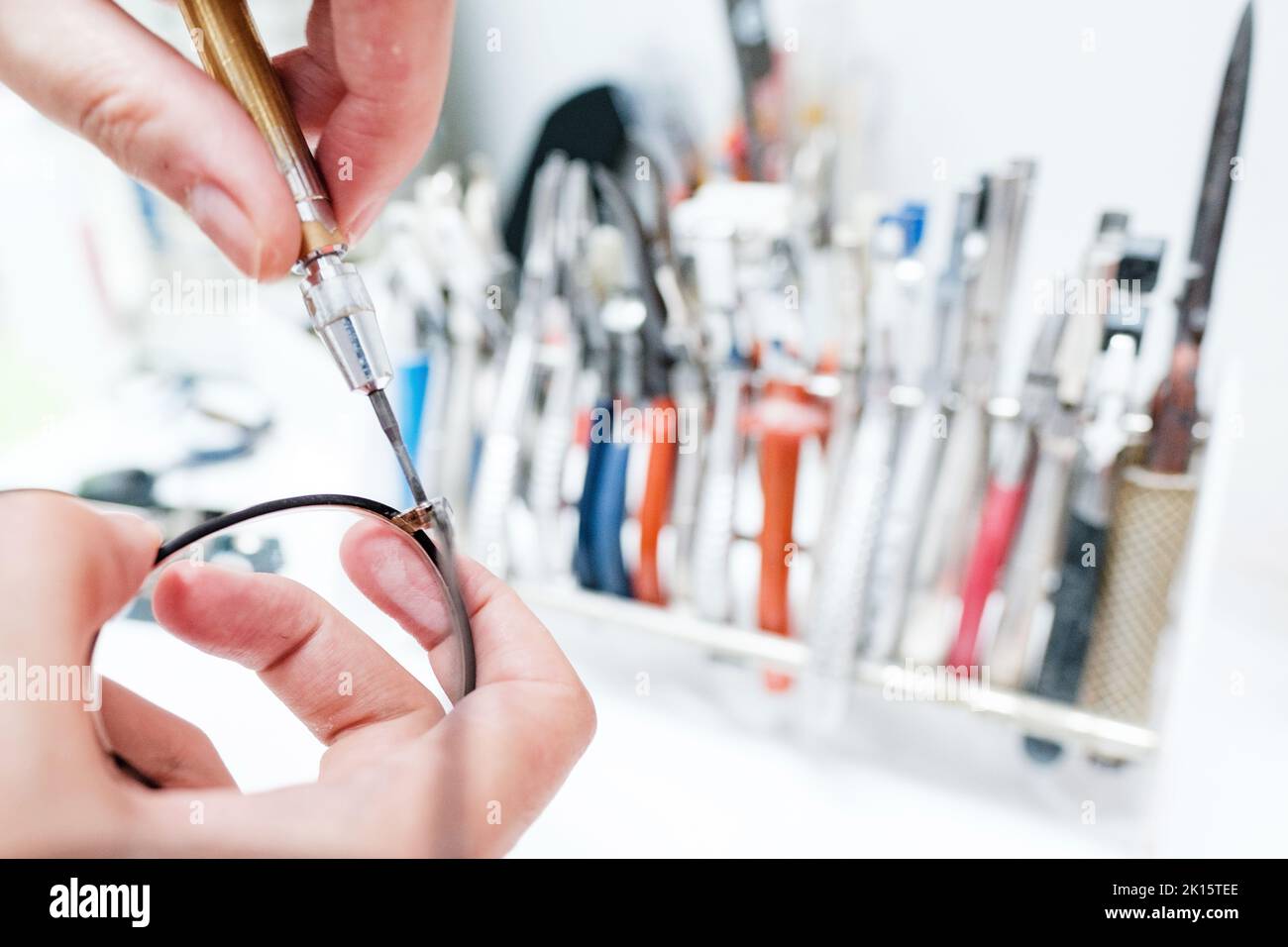 From above of crop anonymous ophthalmologist using screwdriver and