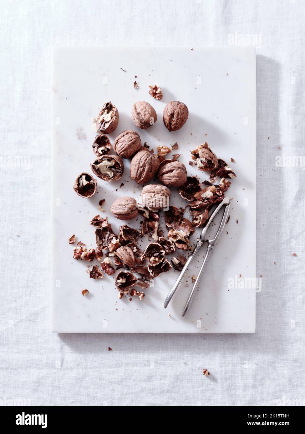 Opening walnuts with a cracker top view. White background Stock Photo