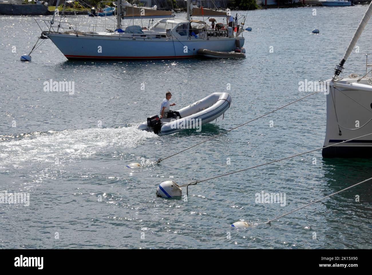 Man in small inflatable boat with outboard engine on Simpson Bay Lagoon, Saint Martin, Caribbean Stock Photo