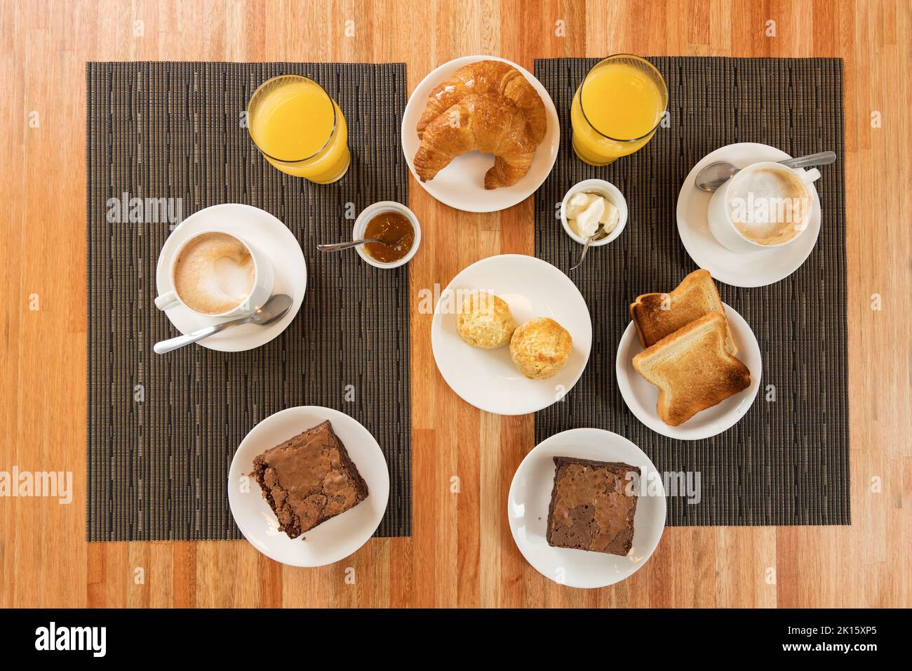 Top view of various pastry and drinks placed near near bowls with sauces on table during breakfast in restaurant Stock Photo