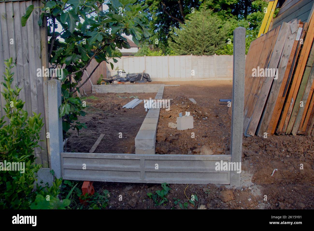 Temporary placement of a concrete gravel board during construction of  a fence Stock Photo