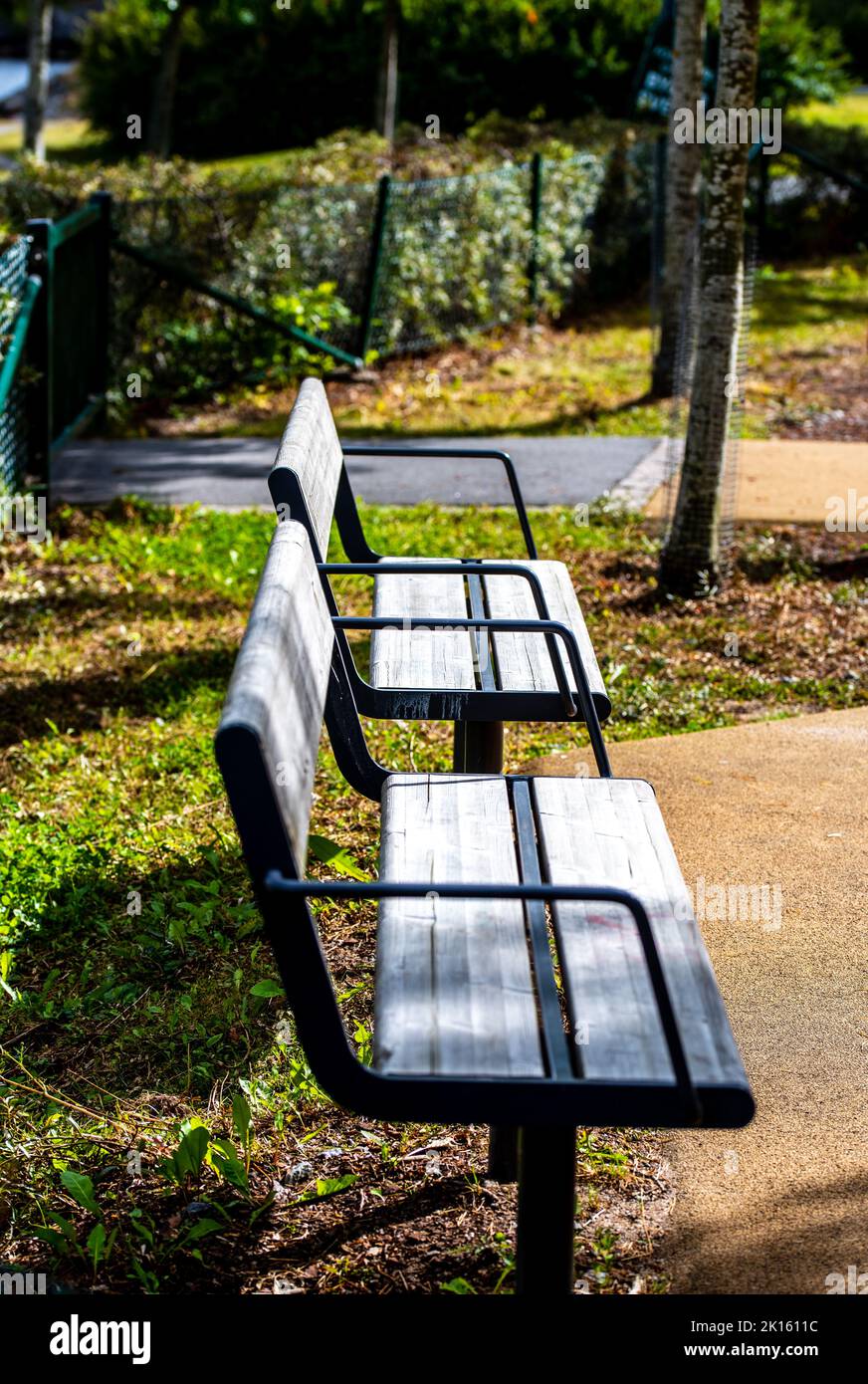two empty benches in a park in the setting sun Stock Photo