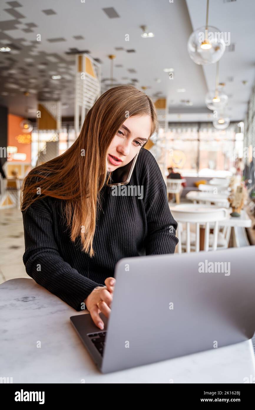young girl in a cafe talking on the phone Stock Photo