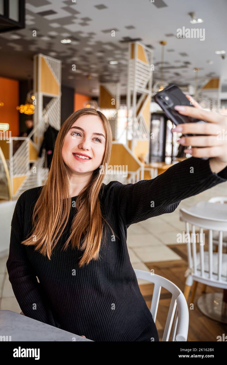 young girl in a cafe taking a selfie Stock Photo - Alamy