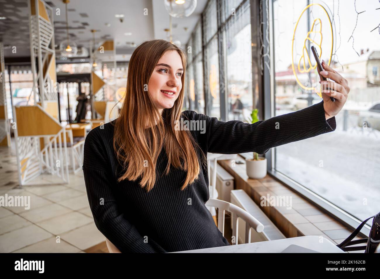 young girl in a cafe taking a selfie Stock Photo - Alamy