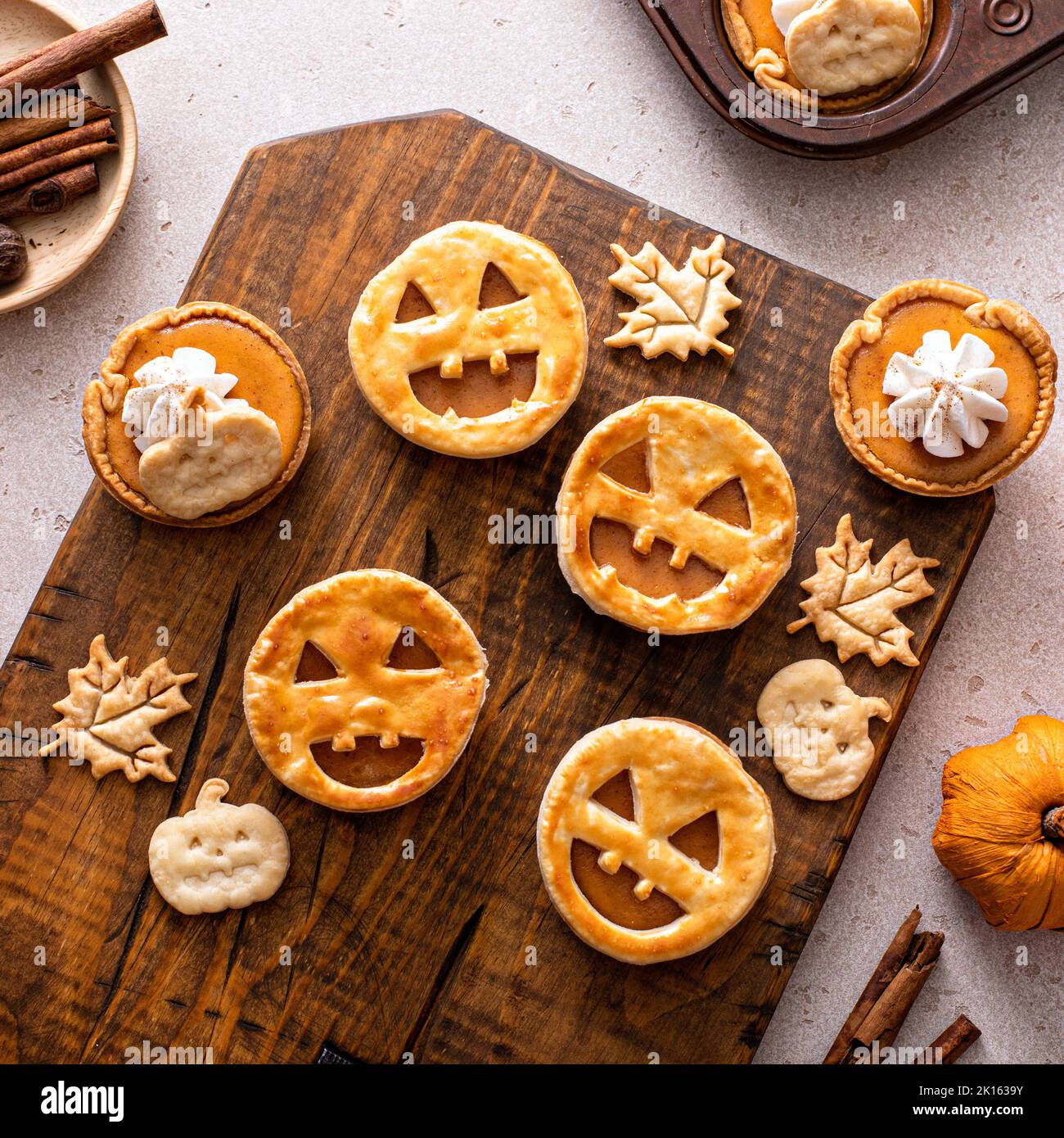Halloween pumpkin pies with carved pumpkin face on top Stock Photo