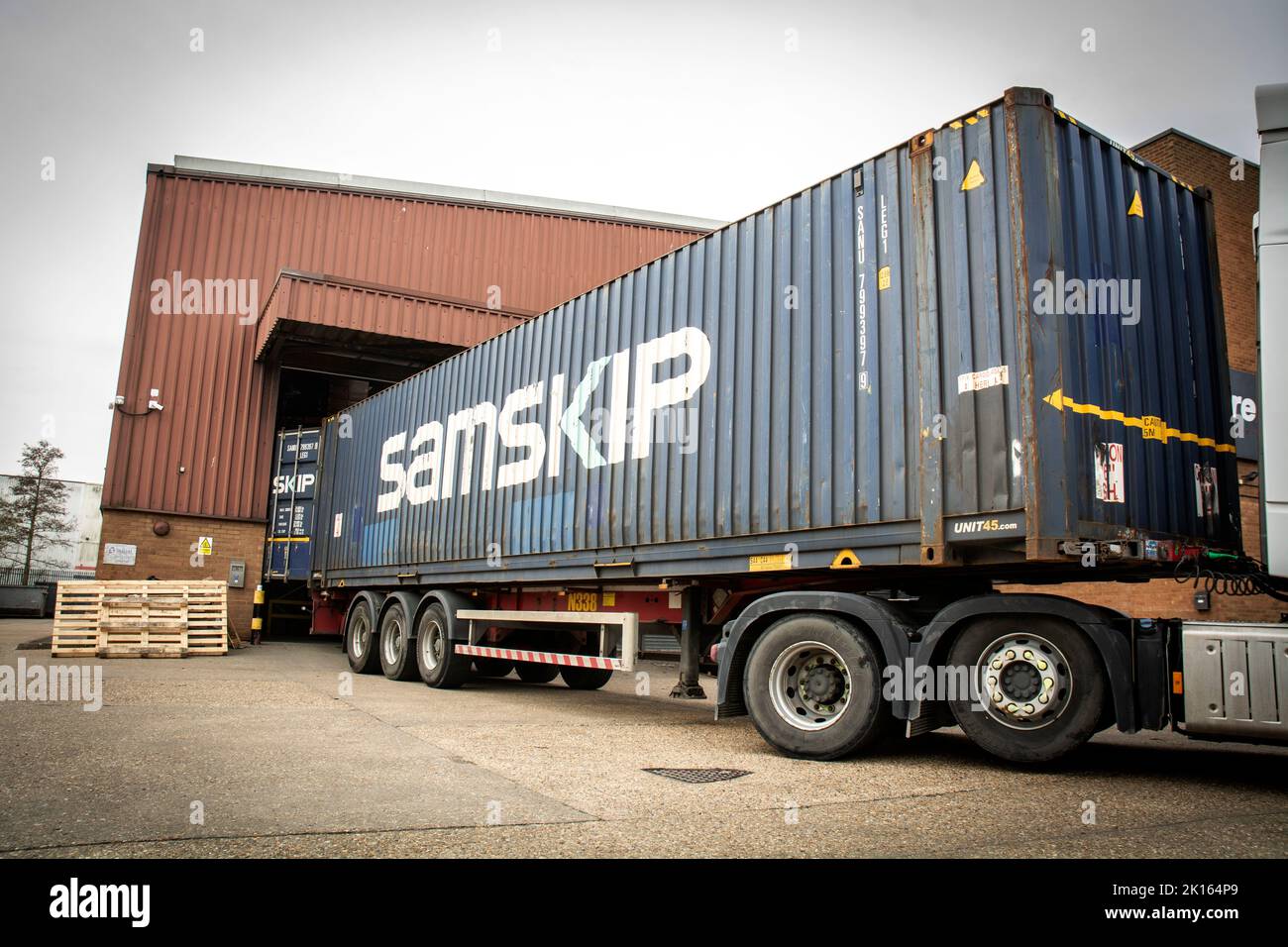 truck delivering cargo and goods in shipping containers, to a warehouse of a business, watford , uk Stock Photo