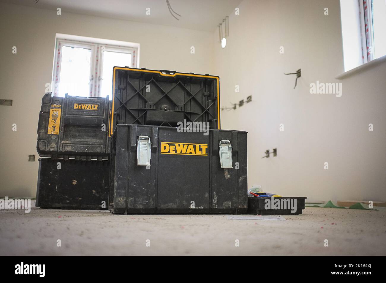 A NEW BUILD, BUILDING SITE WITH DEWALT TOOL STORAGE BOXES IN MIDDLE OF THE ROOM BEING BUILT Stock Photo