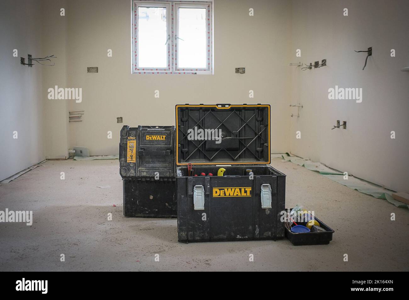 A NEW BUILD, BUILDING SITE WITH DEWALT TOOL STORAGE BOXES IN MIDDLE OF THE ROOM BEING BUILT Stock Photo
