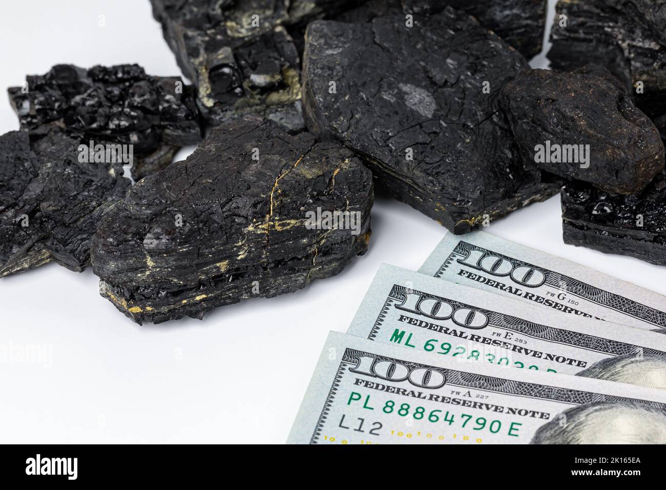Black coal lumps with cash money. Fossil fuel, air pollution and coal mining industry concept. Stock Photo