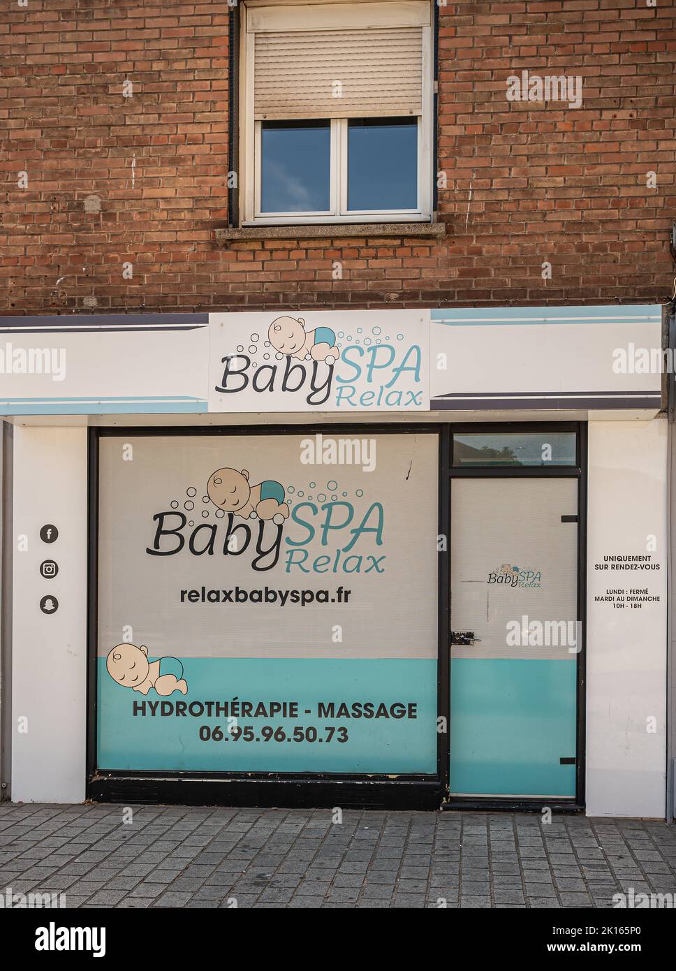 Europe, France, Dunkerque - July 9, 2022: Closeup of Baby spa offers relaxing hydrotherapy and massages for babies. White and aqua blue facade in brow Stock Photo