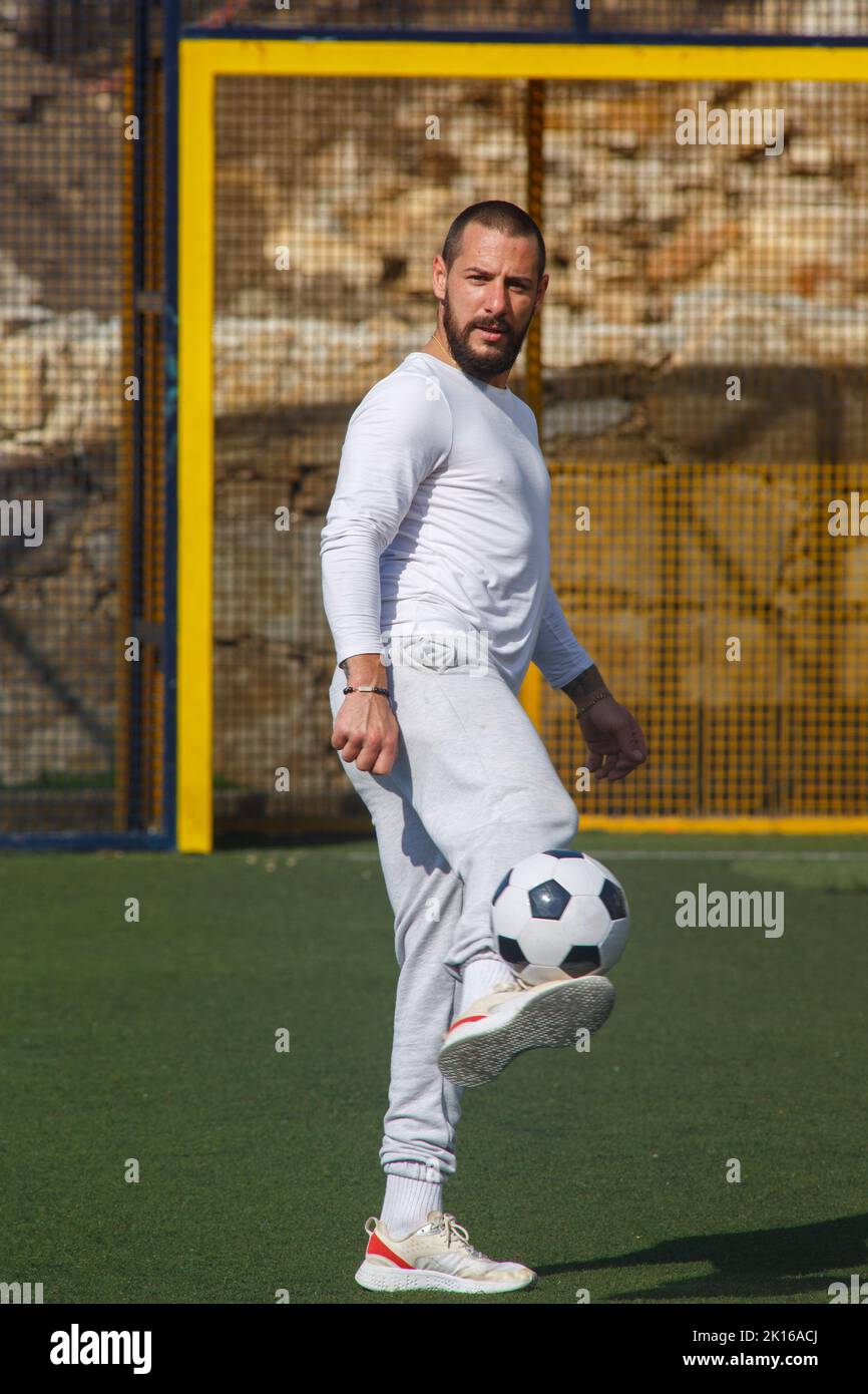 Young male soccer player juggles a ball on a soccer field Stock Photo
