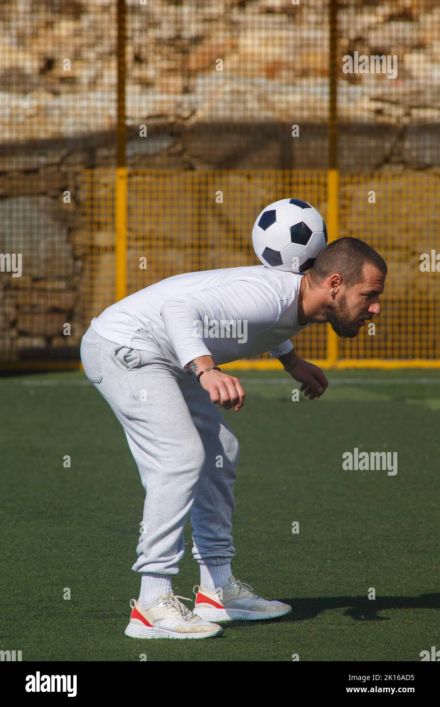 Young male soccer player juggles a ball on a soccer field Stock Photo