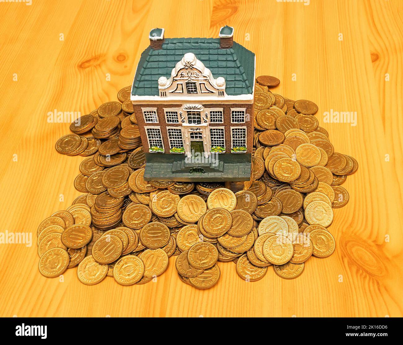 Retro residential house model on pile of gold coins representing concept of climbing property ladder Stock Photo