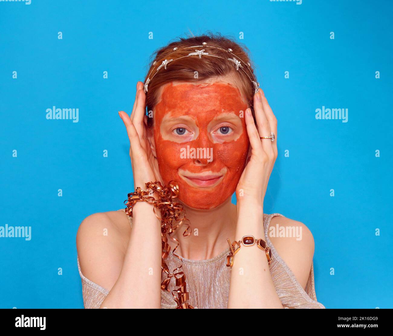Young woman with red clay mask beauty treatment on her face Stock Photo ...