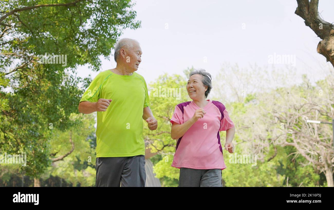 happy senior asian couple exercising and  running in the park Stock Photo